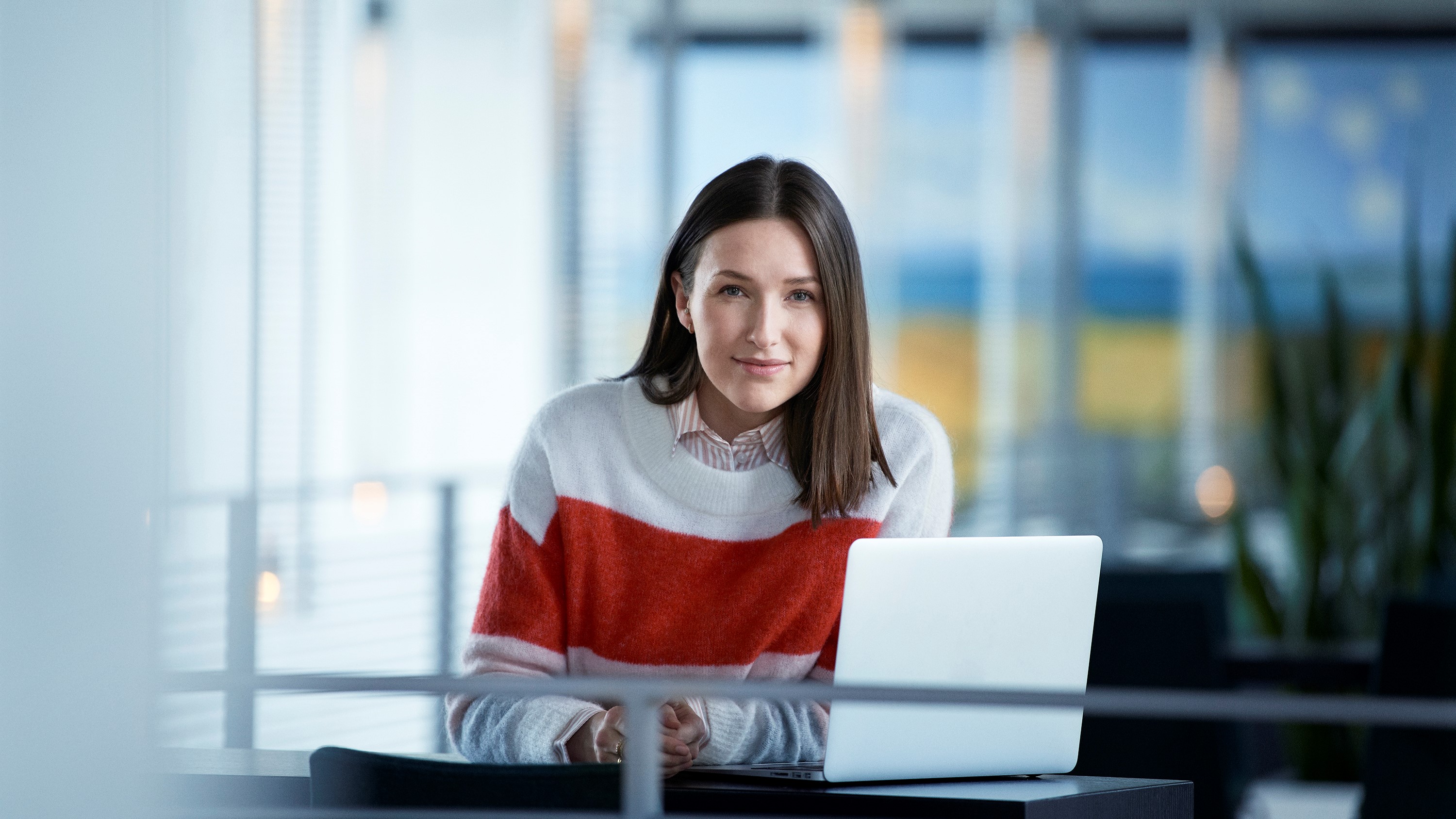 kvinde sidder med bærbar ved bord
