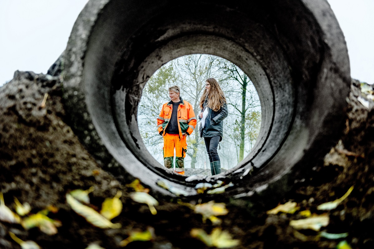 Kvinde og mand set gennem betonrør