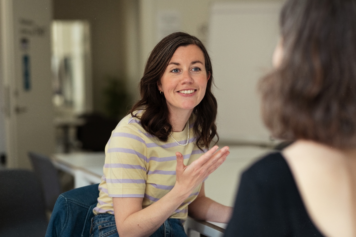 To kvinder taler sammen i et kontor