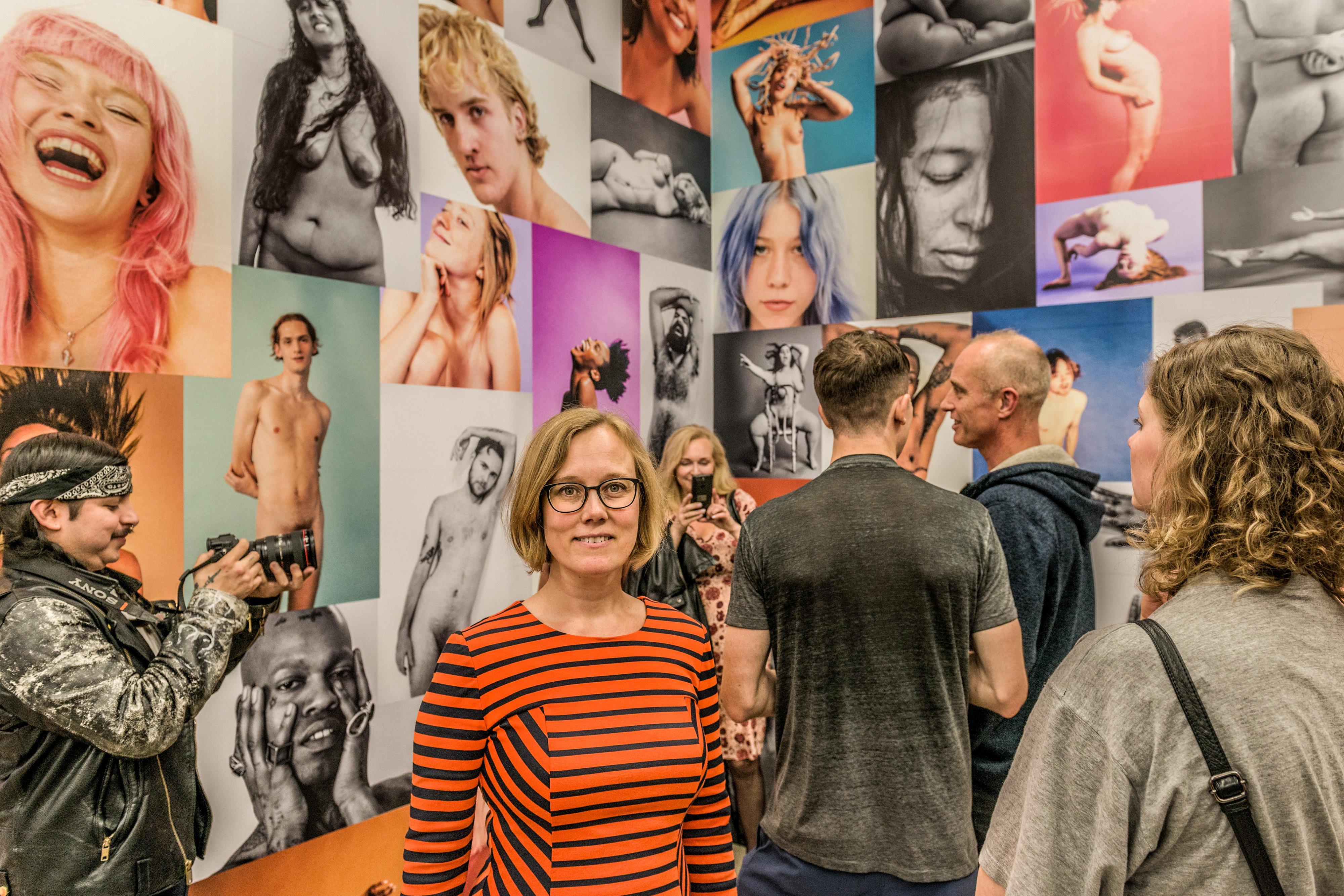 Foto af Camilla Skovbjerg Paldam med billeder i baggrunden