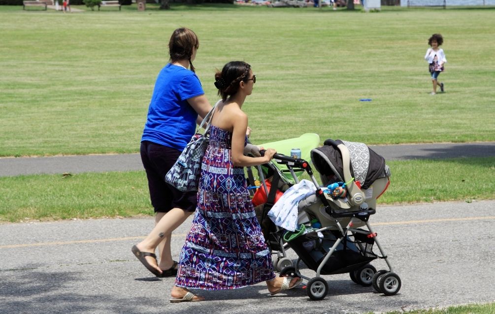 To mødre går tur med klapvogn og børn